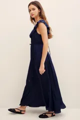 Vestido largo color azul marino con escote redondo, volados en el pecho y mangas cortas con volados. Cuenta con cordón ajustable en la cintura y falda larga fluida.