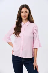 Camisa de lino celeste con cuello clásico, cierre frontal con botones y mangas tres cuartos terminadas en volados.