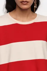 Remera manga larga oversize con diseño de rayas horizontales anchas rojas y blancas, cuello redondo y calce holgado.