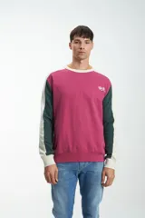 Buzo magenta de corte clásico con mangas largas en bloque de color verde y beige. Estampado con el número 1956 en el pecho.