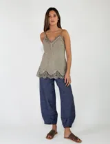 Pantalón azul marino de tiro alto y corte ancho, confeccionado en tejido con textura sutil, bolsillos laterales y cierre frontal con botón.