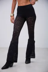 Pantalón de encaje negro, de corte ajustado en la parte superior y acampanado en la parte inferior.