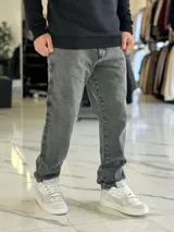 Pantalón de jean gris con lavado ácido, corte holgado de estilo oversize y diseño recto.