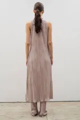 Vestido midi de diseño plisado en color rosado, con cuello alto y sin mangas. Presenta un tajo lateral y corte holgado, diseñado para ser usado en conjunto con pantalones del mismo tejido.