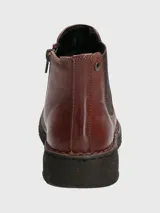 Botín de cuero color marrón con paneles elásticos laterales negros, diseño tipo Chelsea y suela de goma flexible negra con costuras decorativas visibles.