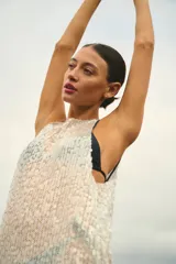 Vestido largo sin mangas, de corte amplio y confeccionado en lentejuelas color plateado.