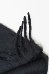 Bufanda de lana con diseño de bloques de color en tonos negro y gris.