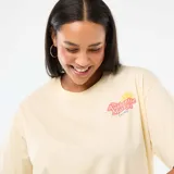 Camiseta de corte oversize color amarillo claro, con cuello redondo y mangas cortas con dobladillo. Presenta un estampado pequeño en el pecho con la frase 'The Authentic Market' y un gráfico de una rodaja de limón.