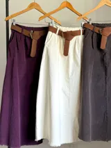 Falda midi de micro pana color morado oscuro, de corte recto y cintura elastizada. Incluye un cinturón desmontable de cuero marrón.