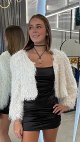 Chaqueta corta de textura peluda en color blanco, con diseño de manga larga y frente abierto.