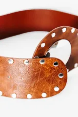 Cinturón ancho de cuero color marrón, con apliques de tachas plateadas y hebilla circular plateada.