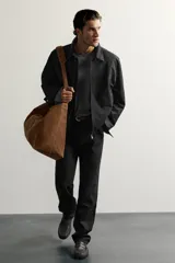 Jeans slim straight fit para hombre, confeccionados en denim de algodón negro sin lavados. Presentan diseño de tiro bajo, pierna recta y cinco bolsillos, con cierre frontal de botonadura.