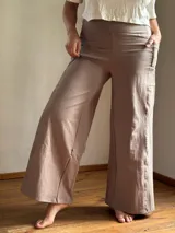 Pantalón palazzo de lycra de algodón color gris claro, de tiro alto, con bolsillos laterales y faja ancha en la cintura.