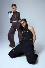 Pantalón cargo de denim negro, con cintura elástica y grandes bolsillos cargo a los lados con botones metálicos plateados.