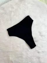 Pack de tres bombachas tipo tanga con diseño de encaje y tiras ajustables. El set incluye modelos en colores bordó, negro y blanco, confeccionados con detalles de encaje floral y terminaciones delicadas.