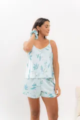 Pijama de seda estampada con diseño floral en tonos celestes y blancos. Incluye una musculosa con escote en V y espalda recta, y un short con elástico en la cintura.