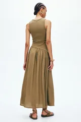 Vestido midi verde militar sin mangas, con cuello redondo y costura fruncida en diagonal bajo la cintura. Cuerpo entallado en punto acanalado de algodón y falda con vuelo.