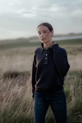 Buzo de punto gris con cuello camisero de denim y cierre frontal parcial con botones metálicos. Presenta mangas largas y un diseño de calce holgado.