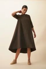 Vestido midi acampanado de lana fina sin teñir, con cuello bote, mangas tres cuartos con tajo y bolsillos laterales. Diseño forrado con vuelo y movimiento.