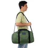 Bolso tipo duffel Jansport Weekender Medium, color verde oliva, con asas de mano y correa de hombro ajustable en color negro. Presenta un bolsillo frontal con cierre y el logo de la marca bordado.