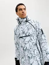 Campera anorak de ski técnica impermeable y cortaviento con capucha ajustable. Presenta un diseño tipo canguro con bolsillo frontal con cierre y solapa con velcro, ventilación bajo los brazos y puños ajustables. Confeccionada en tejido resistente con estampado marmolado.