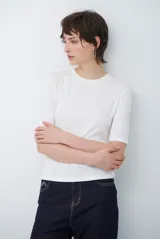 Remera básica de algodón color blanco, con cuello redondo y mangas que llegan hasta el codo.