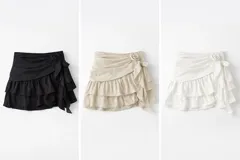 Minifalda con volados, tiro bajo y detalle de flor lateral. Presenta un diseño con movimiento y caída ligera.