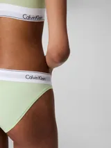 Conjunto Calvin Klein color verde claro, compuesto por un corpiño deportivo con espalda racerback y cintura elástica con logo, y una bombacha clásica con cintura elástica con logo.