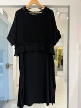 Vestido midi negro con superposición de tejido de red y mangas cortas con detalles desmechados.