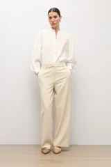 Pantalón sastrero de corte recto y tiro medio, en color beige claro, con presillas para cinto y bolsillos funcionales.