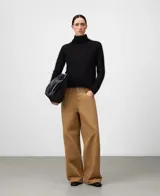 Sweater de punto cardado color negro, con cuello chimenea y manga larga. Confeccionado en una mezcla de mohair y liocel que proporciona ligereza, calidez y un tacto suave. Presenta un diseño minimalista con una caída fluida y brillo sutil.