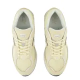 Championes urbanos New Balance modelo 2002R, color beige, confeccionados en una combinación de gamuza y malla transpirable. Presentan el logo N característico en los laterales, entresuela con tecnología N-ergy para mayor amortiguación y suela de goma resistente.