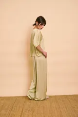 Pantalón palazzo de satén color verde, de tiro alto y corte amplio con bolsillos laterales.