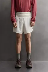 Short deportivo de trail running confeccionado en tejido técnico elástico con textura. Presenta una cintura elástica ancha con compartimentos integrados, bolsillo trasero con cierre y aberturas laterales en el bajo.