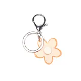 Llavero con dije en forma de flor de cinco pétalos, realizado en resina color naranja traslúcido con centro blanco, unido a una argolla metálica plateada con cierre de mosquetón.