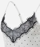 Camisón largo de satén con estampado de lunares, breteles finos ajustables y detalle de encaje negro en el escote.