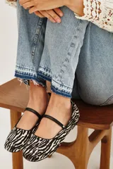 Balerinas de cuero vacuno con estampado de cebra en blanco y negro, y tira fina de cuero negro sobre el empeine.