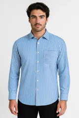Camisa de manga larga a rayas verticales celestes y blancas, con cuello clásico y bolsillo de parche en el pecho. Cierre frontal con botones.