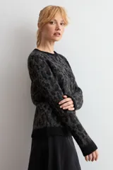 Sweater de punto con diseño animal print en tonos gris oscuro y negro, de cuello redondo y manga larga.