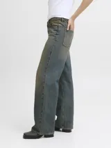 Jean de denim para mujer, de tiro bajo y corte loose fit con pernera amplia. Presenta un lavado con efecto desgastado de tono amarillento, cierre frontal con botón y cinco bolsillos clásicos.