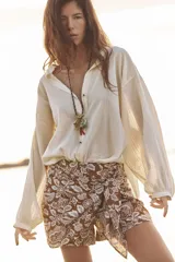 Short de tiro alto con detalle de nudo delantero y bordados florales perforados.