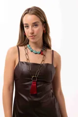 Collar de diseño irregular compuesto por una mitad de cuentas de piedra turquesa y la otra mitad de cuentas de madera, piedras naturales y acrílico, con un dije central en forma de gota roja.