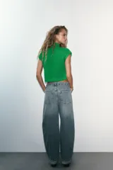 Chaleco de punto acanalado color verde brillante, con cuello alto y mangas sisa caídas.