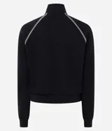 Campera deportiva de cuello alto y cierre frontal, color negro con franjas blancas en las mangas y costuras decorativas contrastantes. Cuenta con bolsillos laterales y puños ajustados.