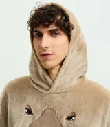 Buzo tipo manta de corte oversize confeccionado en tejido fleece de tacto suave y aspecto peludo. Presenta capucha, mangas largas con puños ajustados y un amplio bolsillo frontal tipo canguro. Incluye un diseño bordado en relieve de una capivara en el frente.