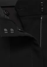 Pantalon de vestir negro de corte flare con diseño de campana, tejido fluido, bolsillos laterales y cierre oculto.