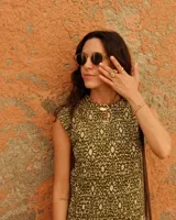 Collar con dije de bronce macizo con forma orgánica irregular, similar a un coral, suspendido de un cordón negro de seda natural anudado.