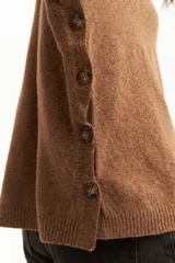 Sweater azul petróleo de tejido de punto, con cuello redondo y botones decorativos en los laterales.