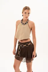 Top de gamuza color visón con escote halter y costuras decorativas con detalle de tientos de cuero en los bordes laterales.
