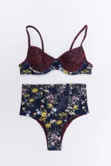 Bikini de dos piezas en combinación de colores negro y mostaza. El corpiño es de estilo triangular con base y breteles finos, mientras que la bombacha es de corte clásico con cintura alta en color negro.